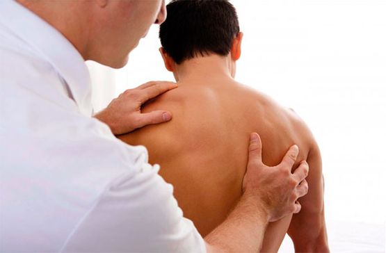 Centro de Fisioterapia Fisiovida Terapeuta revisando espalda de hombre